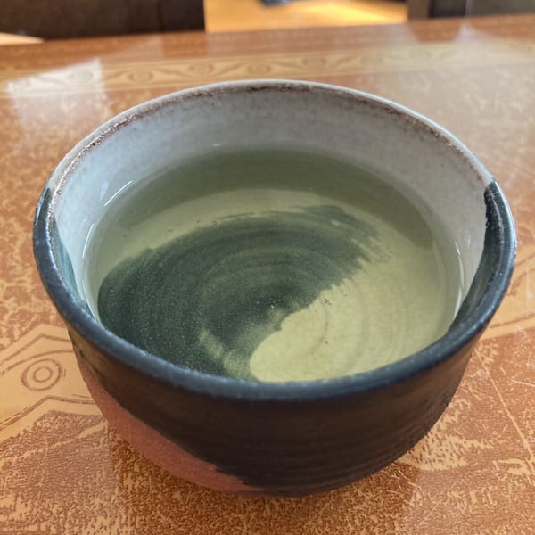 the tea, light green in color in a cup