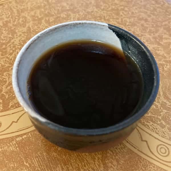the tea, almost black in color in a cup