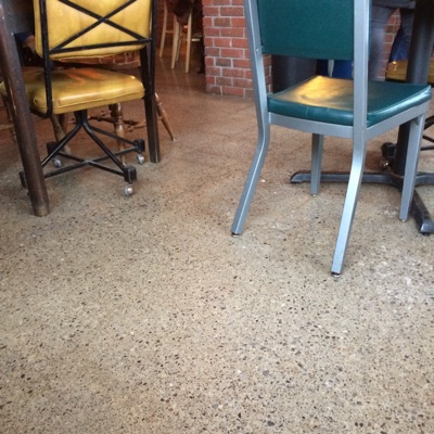 The album cover for 22. It is a photo of two chairs, set up at different tables near each other in a coffee shop. One chair yellow cushions and legs that have wheels on them and the other chair has green cushions and straight non-wheeled legs. They are angled in a way that maybe they could be peaking an eye at each other like two people from across a crowded room.
