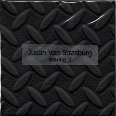 The album cover for snaring__1. It is a photo of a fragment of sleeping mat that has a label with the Justin Von Strasburg snaring__1 written on it.