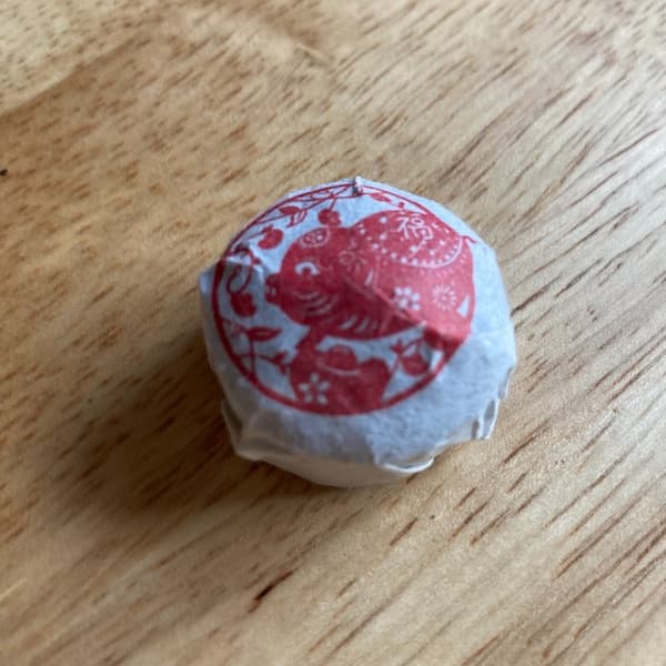 the wrapped tuo, white wrapper with a red drawing of a pig, think something that would appear on Chinese takeout