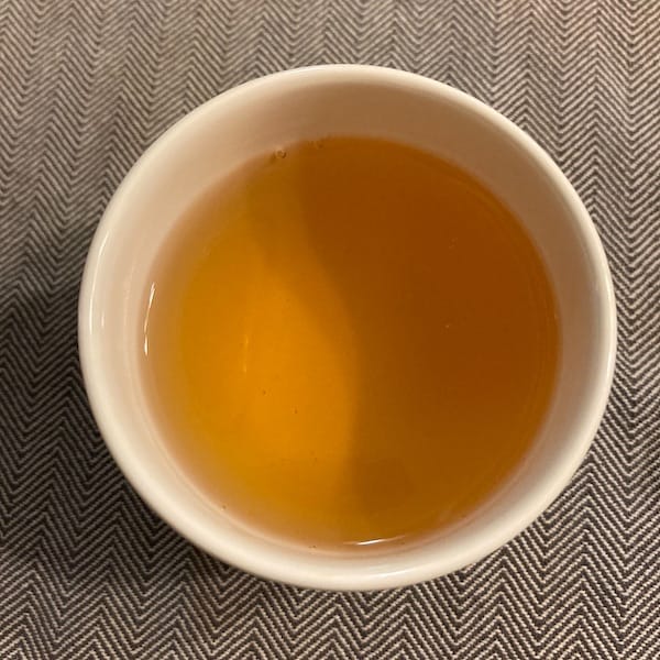 the tea, orange/yellow in color in a cup