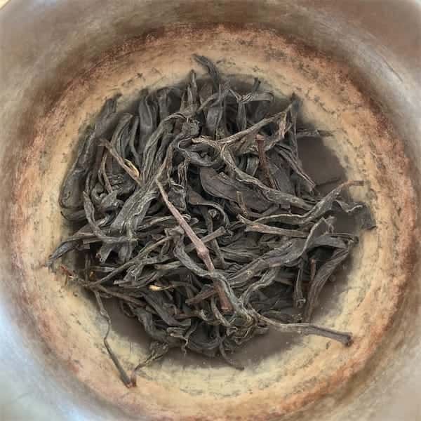 the twisted dark brown and gray leaves in a gaiwan