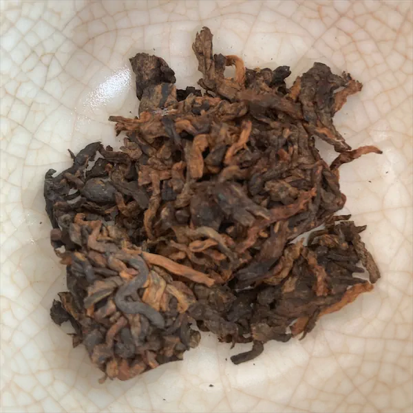 dark brown, brown, and tan leaves in a white porcelain gaiwan