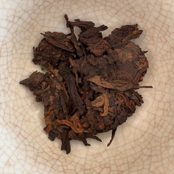 dark brown, brown, and tan leaves in a white porcelain gaiwan